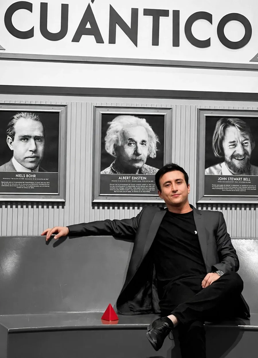 Fabián Flechas, sentado bajo los retratos de Niels Bohr, Albert Einstein y John Stewart Bell